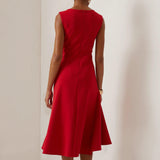 Vestido midi vermelho sem mangas, elegante, em corte A, com detalhe torcido na cintura, perfeito para usar do dia à noite.
