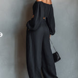 Conjunto de blusa preta de manga comprida com ombros à mostra e calça pantalona