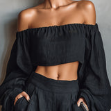 Conjunto de blusa preta de manga comprida com ombros à mostra e calça pantalona
