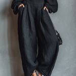 Conjunto de blusa preta de manga comprida com ombros à mostra e calça pantalona