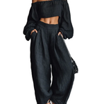Conjunto de blusa preta de manga comprida com ombros à mostra e calça pantalona