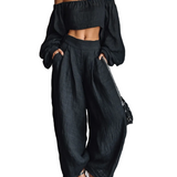 Conjunto de blusa preta de manga comprida com ombros à mostra e calça pantalona