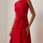 Vestido midi vermelho sem mangas, elegante, em corte A, com detalhe torcido na cintura, perfeito para usar do dia à noite.