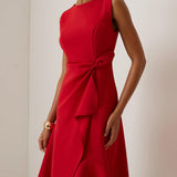 Vestido midi vermelho sem mangas, elegante, em corte A, com detalhe torcido na cintura, perfeito para usar do dia à noite.